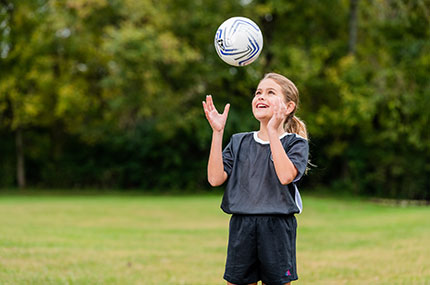 Girl bounces soccer ball off head