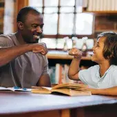 reading tutor fist bumping with kid