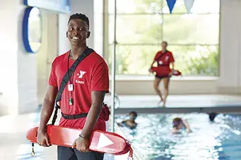 Lifeguard standing next to pool