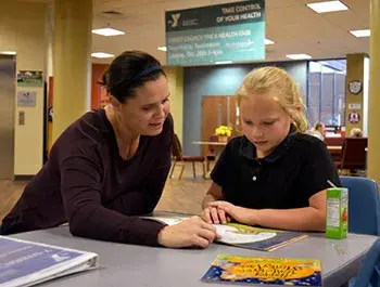 A teacher reads to a student