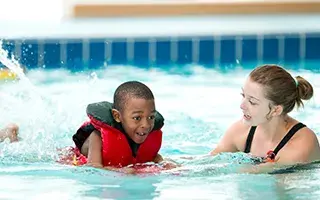 Lifeguard-teaching-boy-to-swim