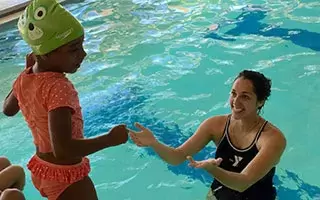 Swim instructor helps student