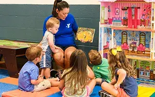 Y staff member reading book to kids