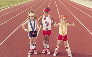 kids standing on track wearing medals