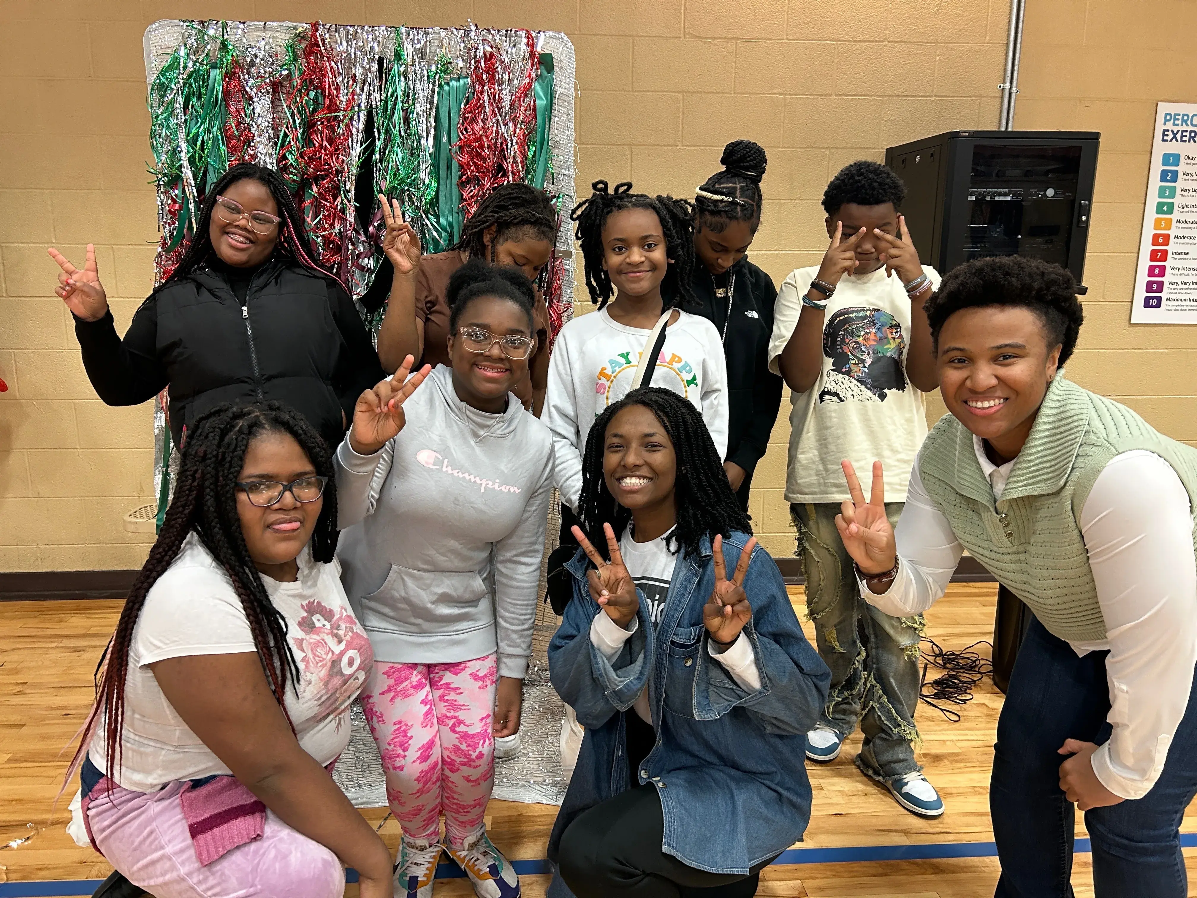 A group of students and volunteers smiling and throwing peace signs