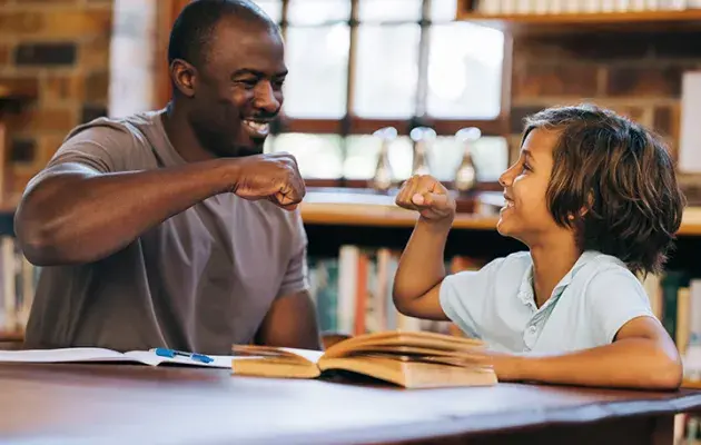 reading tutor fist bumping with kid